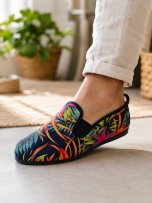 `Pantoufle femme imprimé tropical bleu marine portée avec un pantalon en lin, semelle souple, enfilage sans lacet`